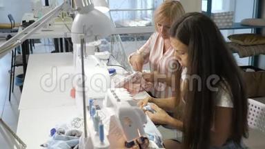 缝纫工人在工作时在缝纫机上缝制衣服，侧视。